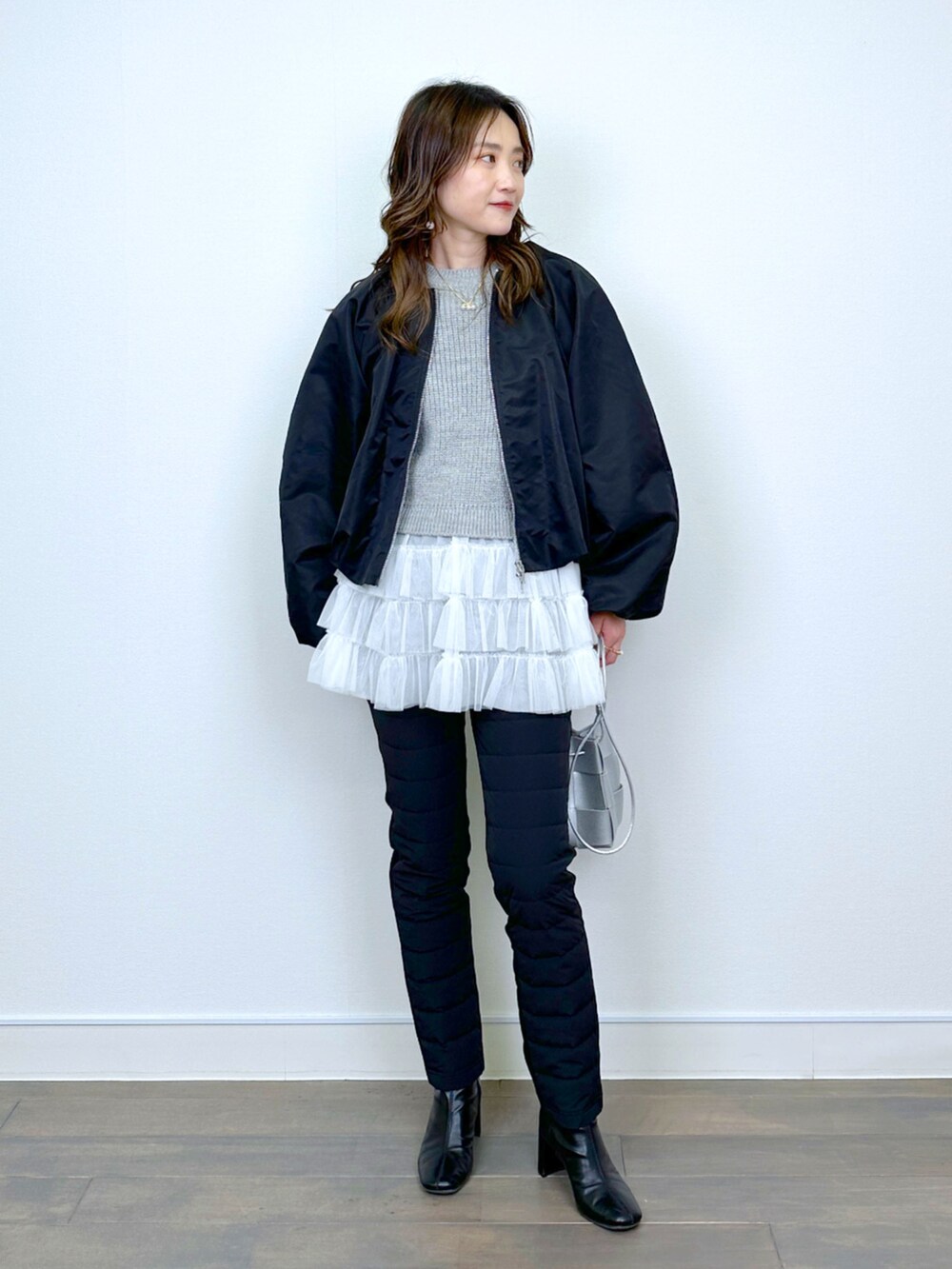 ブラック系のブルゾン、ベージュ系のニット/セーター、ブラック系のその他パンツを着用したレディースの冬コーディネートの5枚目の写真