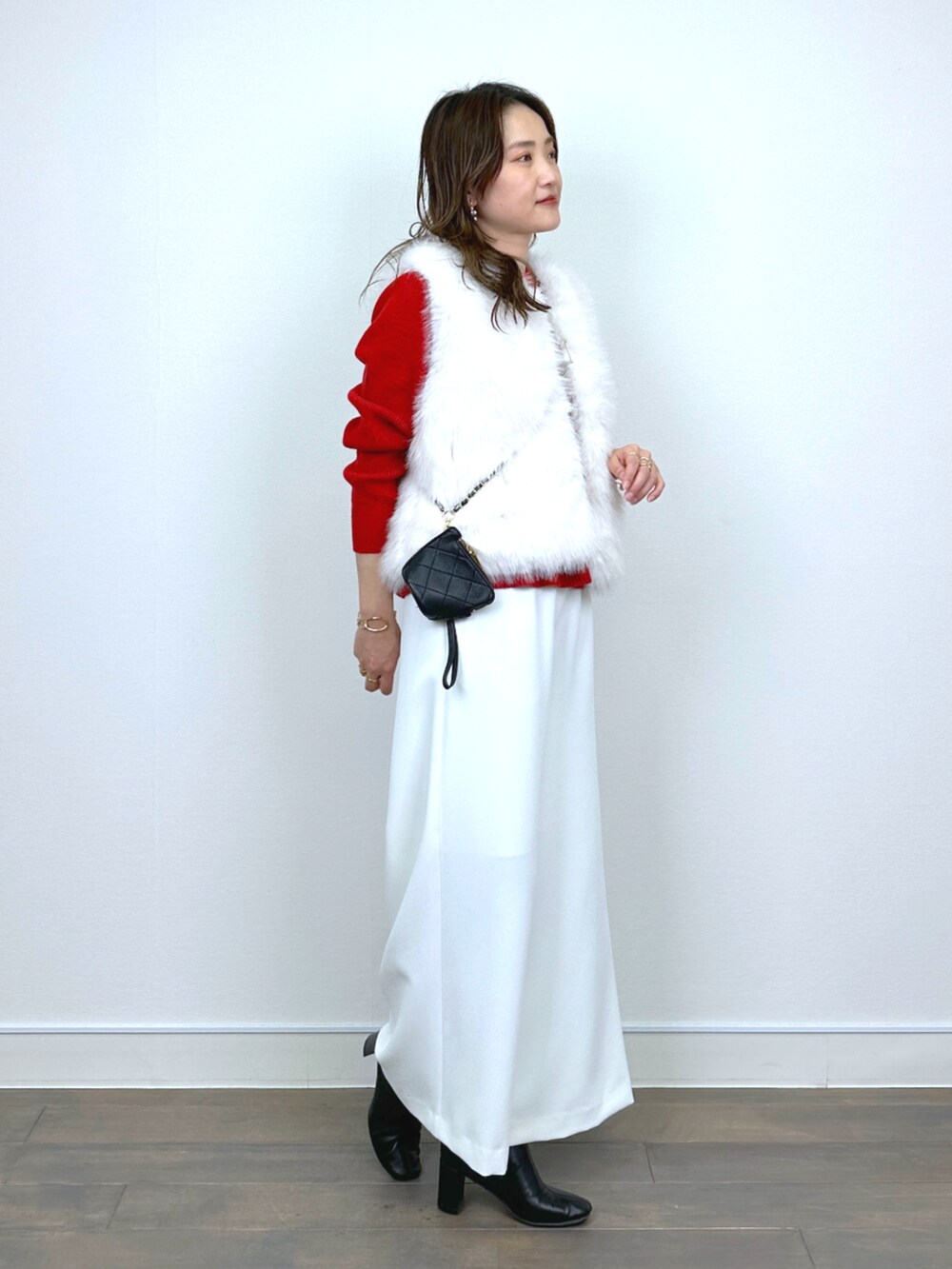 ホワイト系のベスト、レッド系のニット/セーター、ホワイト系のその他パンツを着用したレディースの秋コーディネートの2枚目の写真