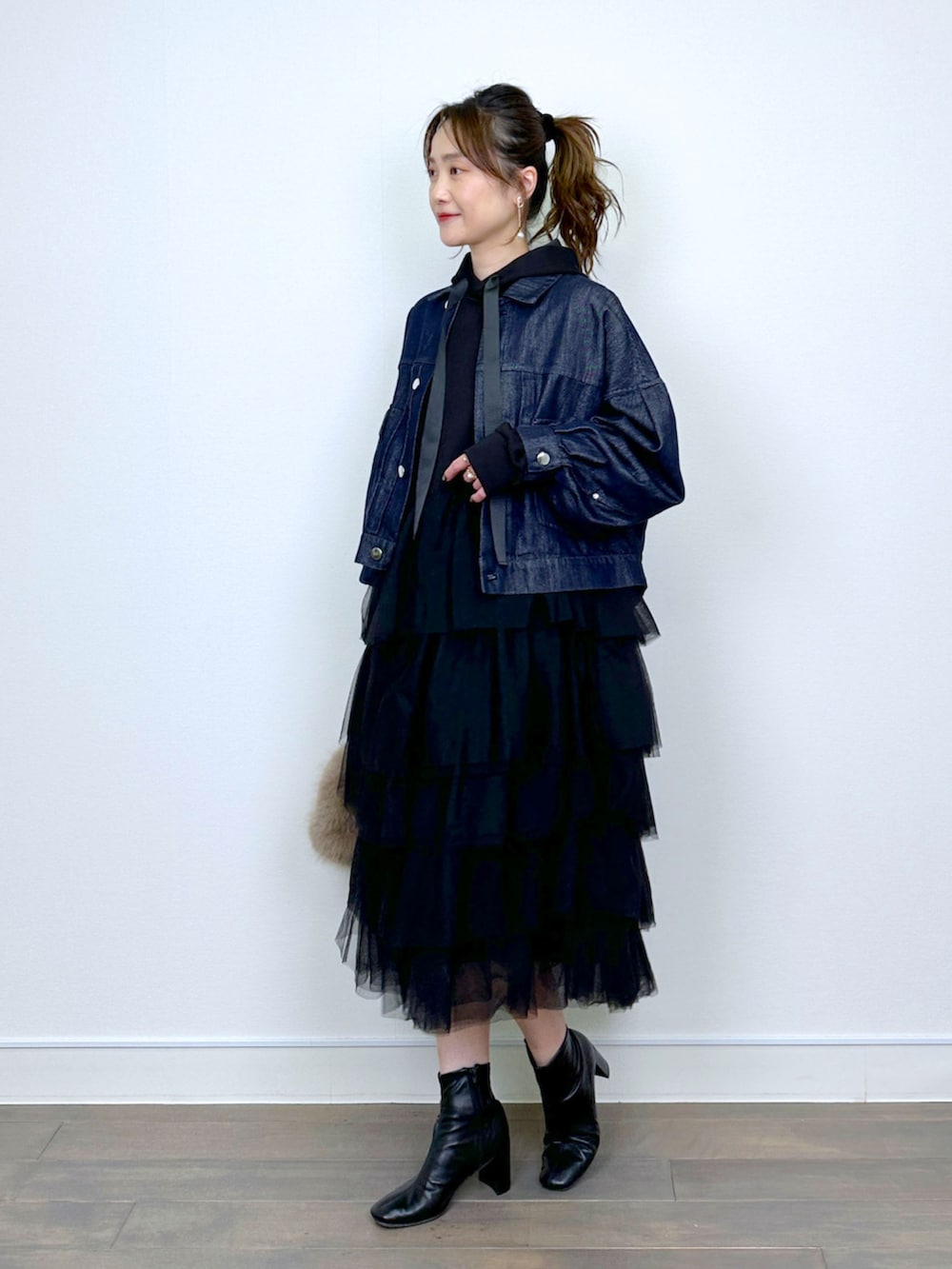 ブルー系のデニムジャケット、ブラック系のワンピースを着用したレディースの冬コーディネートの4枚目の写真