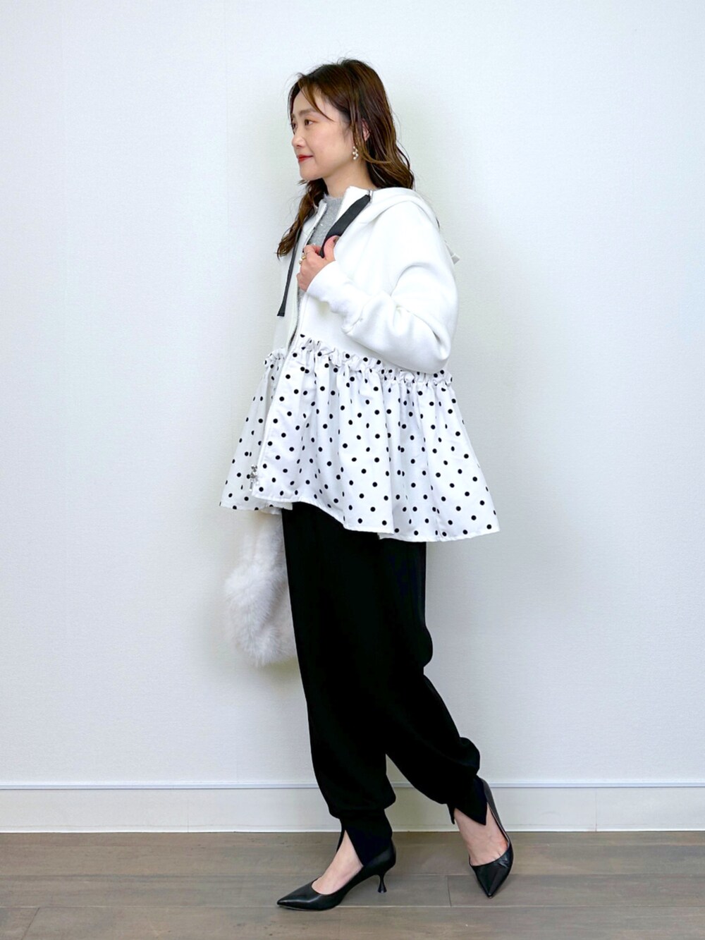 シルバー系のニット/セーター、ブラック系のその他パンツ、ホワイト系のパーカーを着用したレディースの冬コーディネートの4枚目の写真