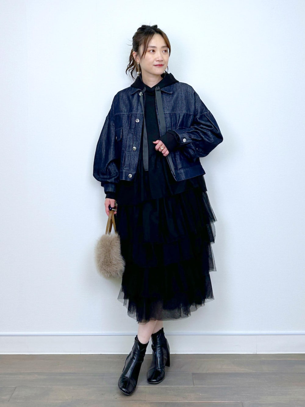 ブルー系のデニムジャケット、ブラック系のワンピースを着用したレディースの冬コーディネートの5枚目の写真