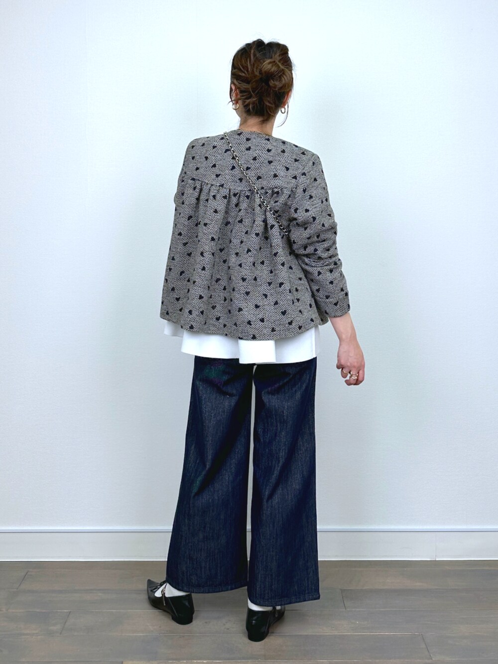 ブラウン系のブルゾン、ホワイト系のニット/セーター、ブルー系のデニムパンツを着用したレディースの冬コーディネートの3枚目の写真