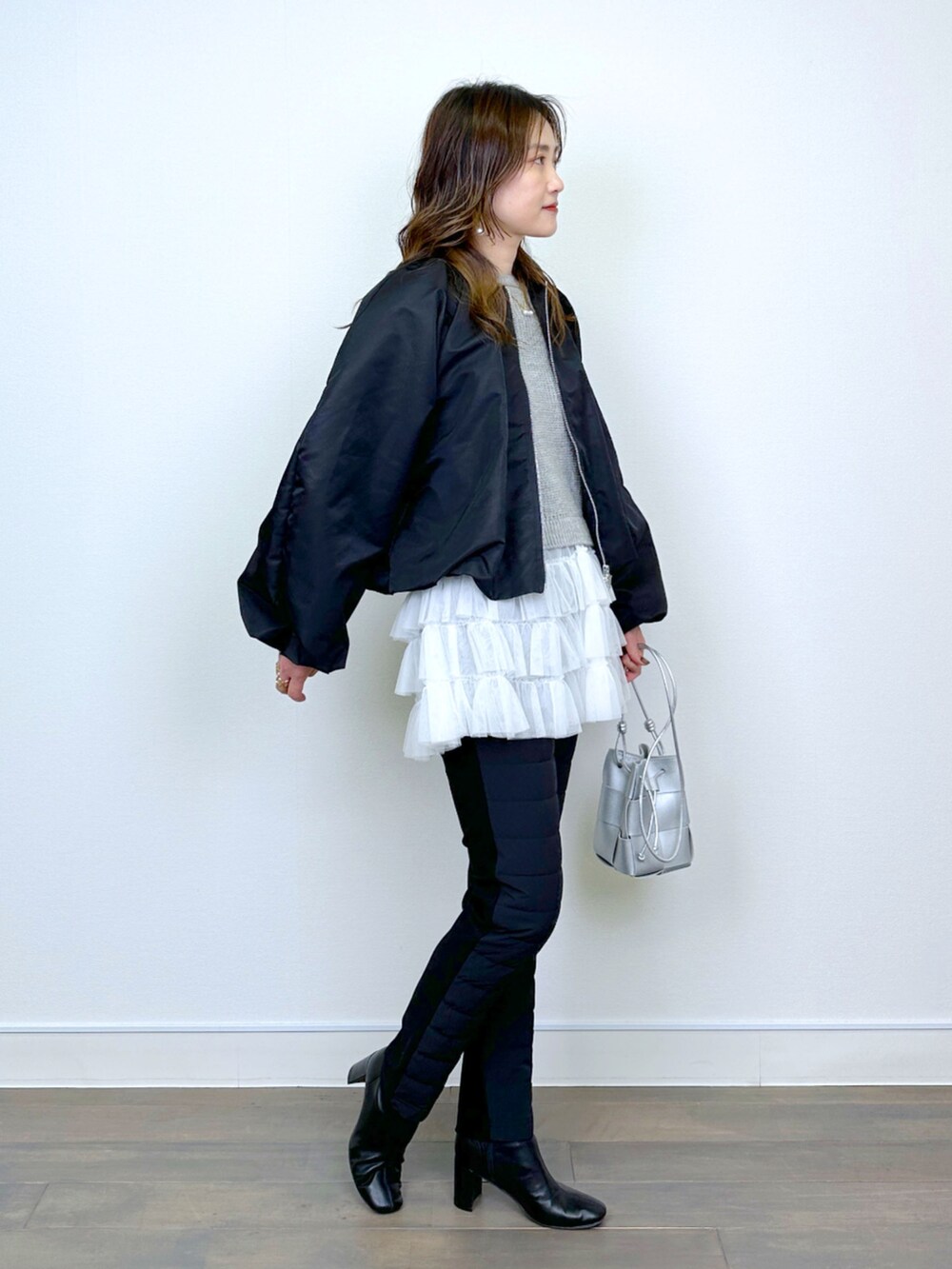 ブラック系のブルゾン、ベージュ系のニット/セーター、ブラック系のその他パンツを着用したレディースの冬コーディネートの2枚目の写真