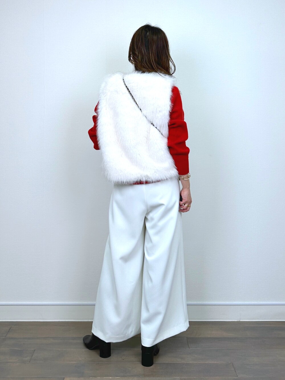 ホワイト系のベスト、レッド系のニット/セーター、ホワイト系のその他パンツを着用したレディースの秋コーディネートの3枚目の写真