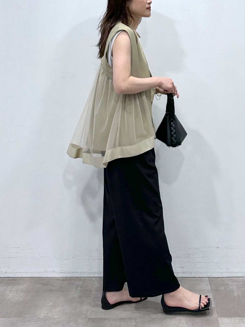 ベージュ系のベスト、ホワイト系のTシャツ/カットソー、ブラック系のその他パンツを着用したレディースの夏コーディネートの2枚目の写真