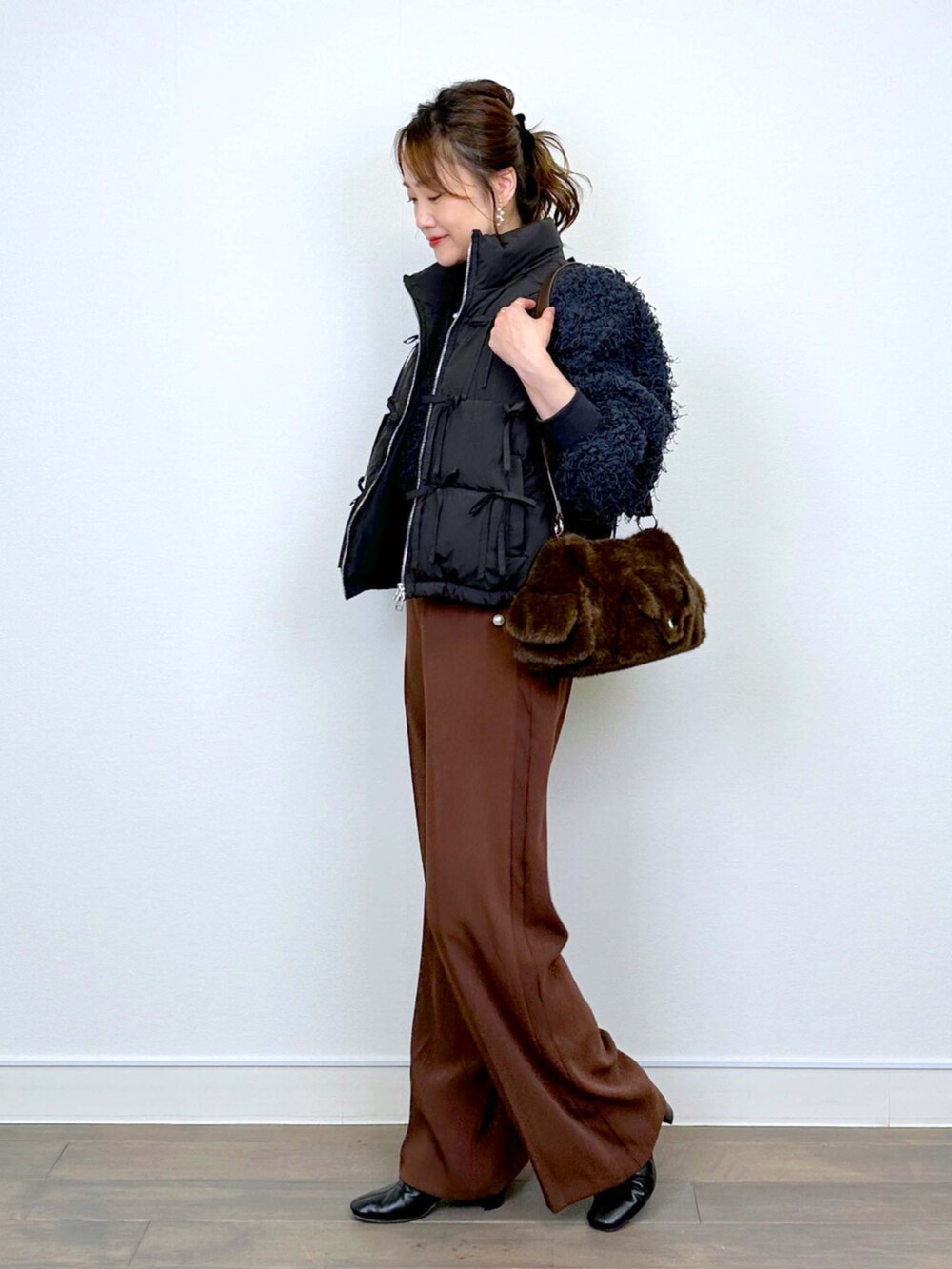 グレー系のTシャツ/カットソー、ブラウン系のスラックスを着用したレディースの冬コーディネートの2枚目の写真