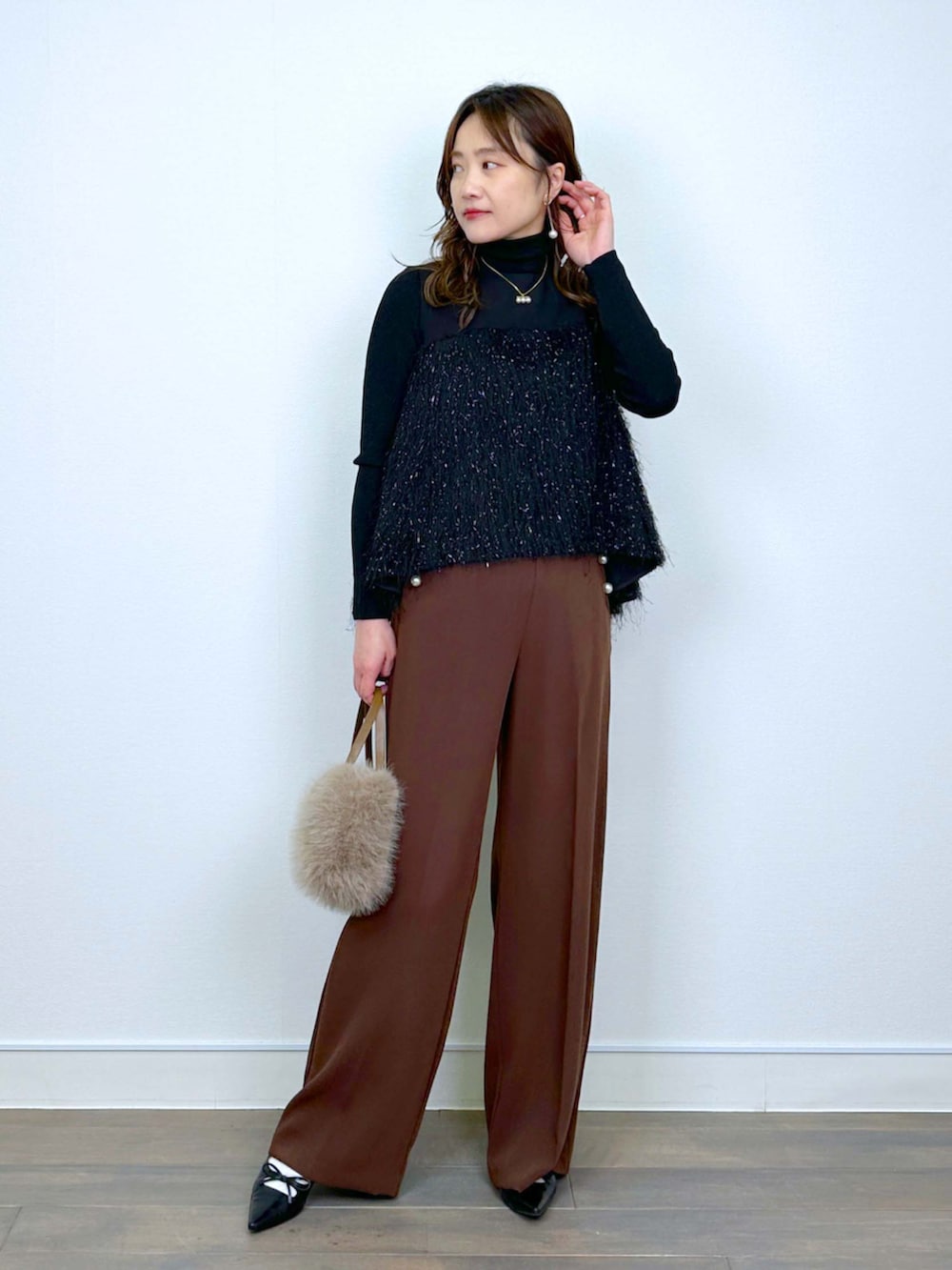 ブラウン系のスラックス、ブラック系のシャツ/ブラウス、ブラック系のニット/セーターを着用したレディースの冬コーディネートの5枚目の写真