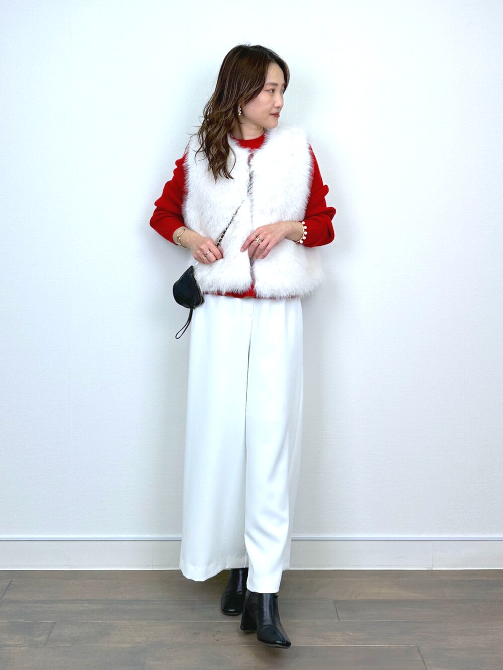 ホワイト系のベスト、レッド系のニット/セーター、ホワイト系のその他パンツを着用したレディースの秋コーディネートの5枚目の写真
