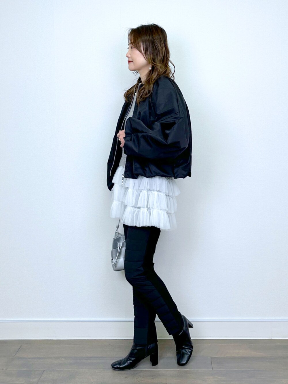 ブラック系のブルゾン、ベージュ系のニット/セーター、ブラック系のその他パンツを着用したレディースの冬コーディネートの4枚目の写真