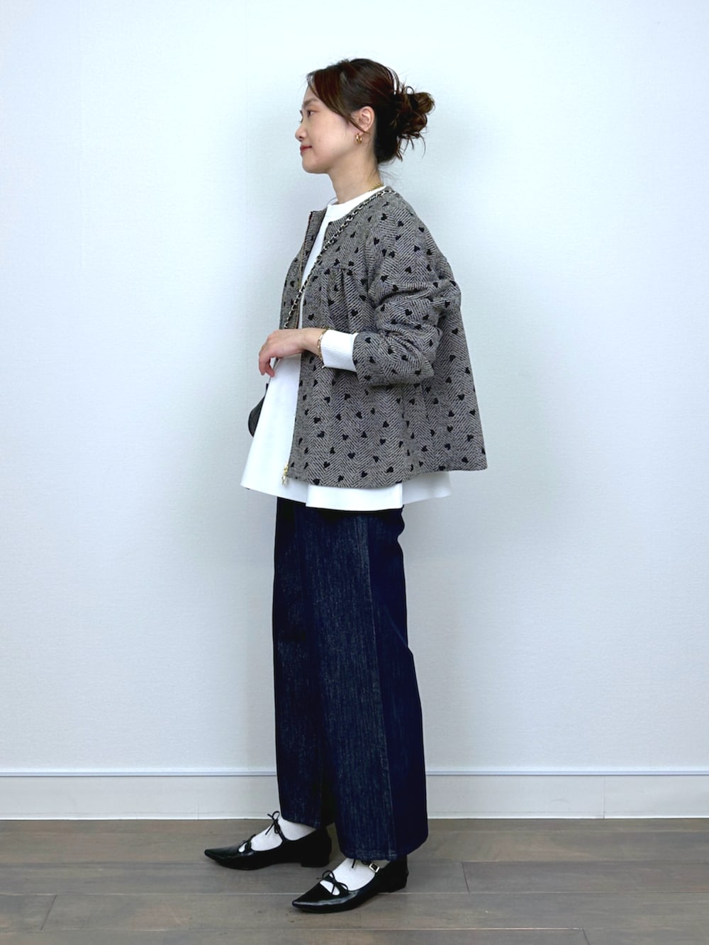 ブラウン系のブルゾン、ホワイト系のニット/セーター、ブルー系のデニムパンツを着用したレディースの冬コーディネートの2枚目の写真