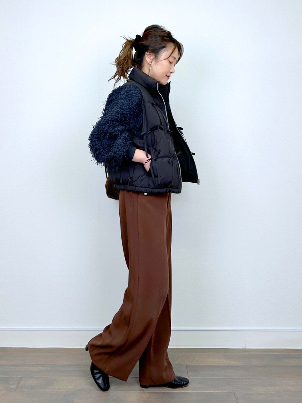 グレー系のTシャツ/カットソー、ブラウン系のスラックスを着用したレディースの冬コーディネートの4枚目の写真