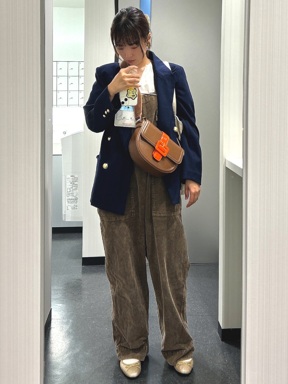 ブラウン系のサロペット/オーバーオール、ゴールド系のバレエシューズ、ホワイト系のシャツ/ブラウスを着用したレディースの秋コーディネートの2枚目の写真