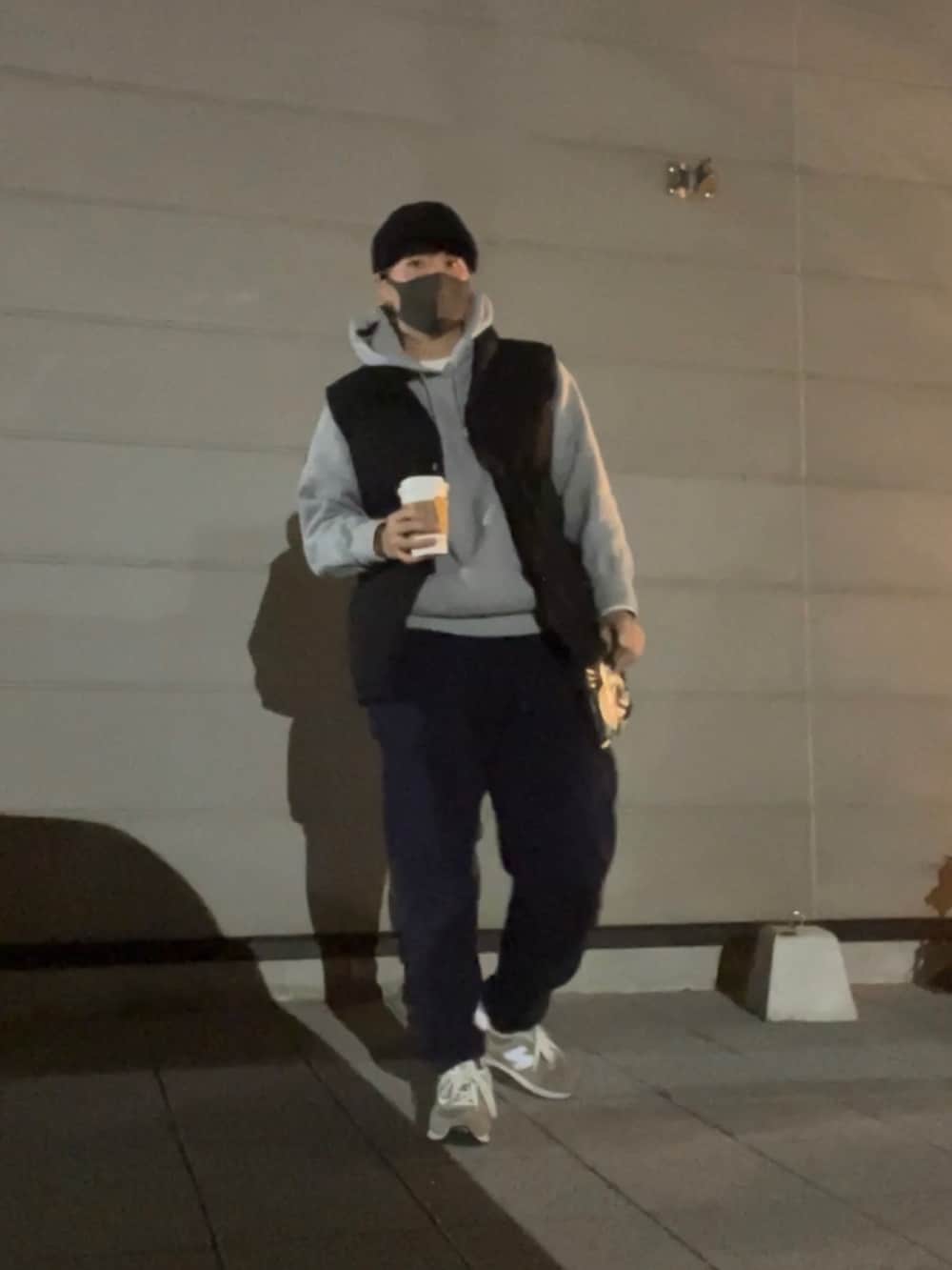 ブルー系のスウェットパンツ、グレー系のパーカー、ブラック系のダウンベストを着用したメンズの冬コーディネートの3枚目の写真