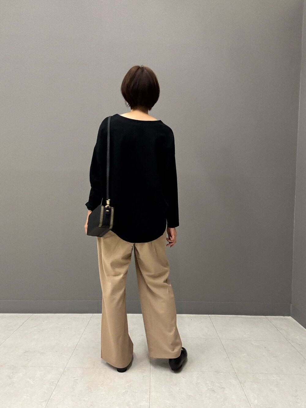 ブラック系のTシャツ/カットソー、ブラック系のショルダーバッグ、ベージュ系のその他パンツを着用したレディースの秋コーディネートの4枚目の写真