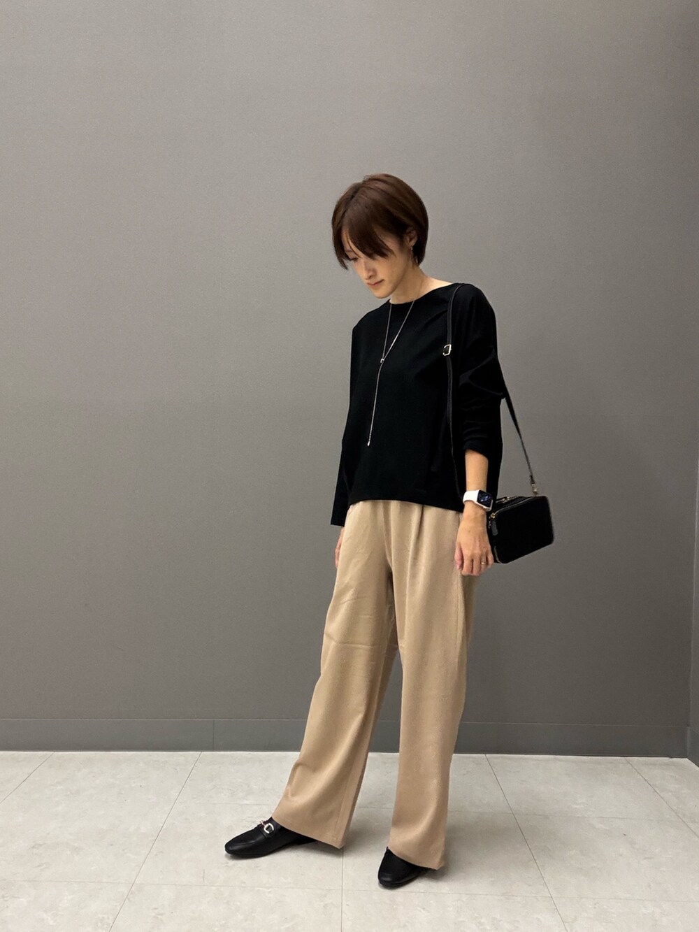 ブラック系のTシャツ/カットソー、ブラック系のショルダーバッグ、ベージュ系のその他パンツを着用したレディースの秋コーディネートの2枚目の写真