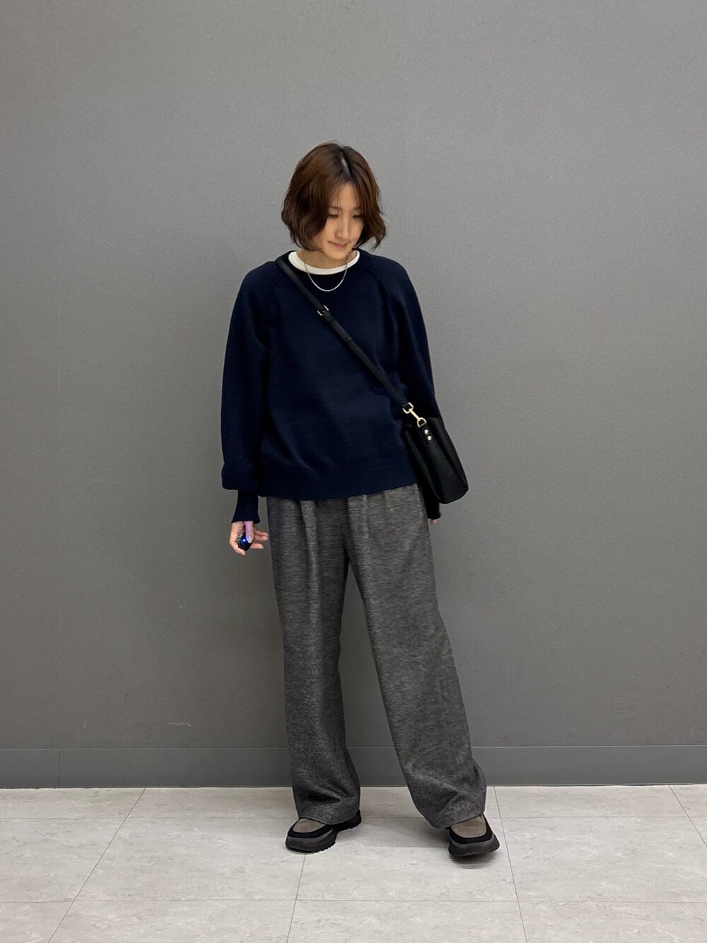 ブラック系のショルダーバッグ、グレー系のその他パンツ、ブルー系のニット/セーターを着用したレディースの冬コーディネートの4枚目の写真