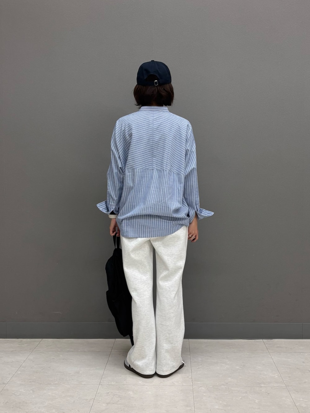 ブルー系のシャツ/ブラウス、ブラック系のバックパック/リュック、ホワイト系のスニーカーを着用したレディースの冬コーディネートの5枚目の写真