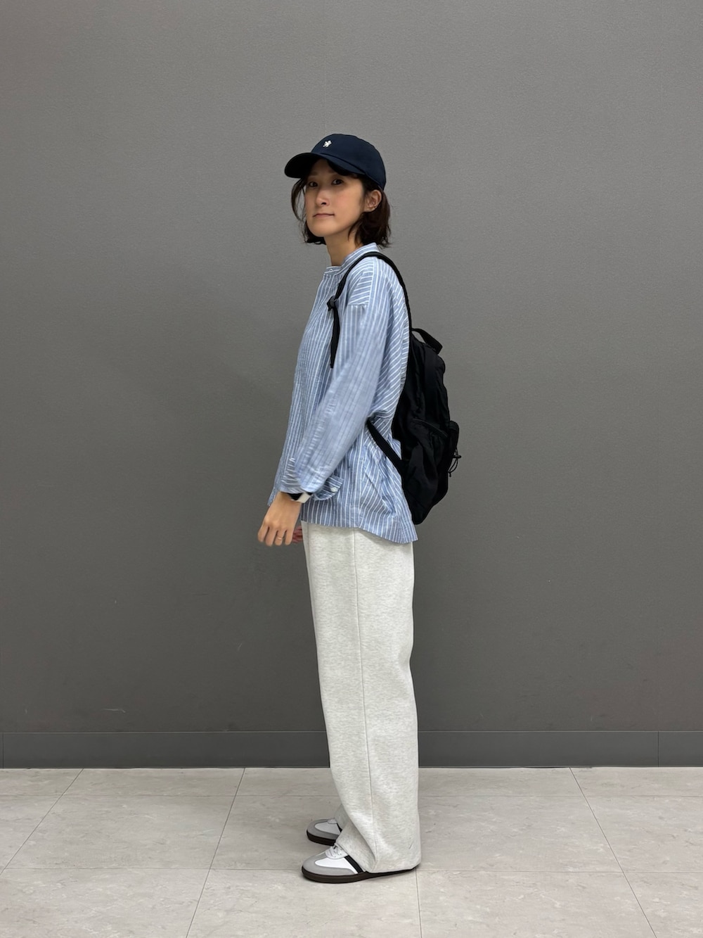 ブルー系のシャツ/ブラウス、ブラック系のバックパック/リュック、ホワイト系のスニーカーを着用したレディースの冬コーディネートの4枚目の写真