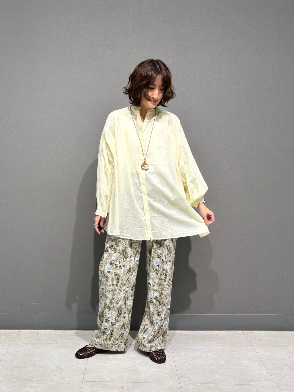 ベージュ系のその他パンツ、イエロー系のシャツ/ブラウス、ブラウン系のサンダルを着用したレディースの春コーディネートの2枚目の写真