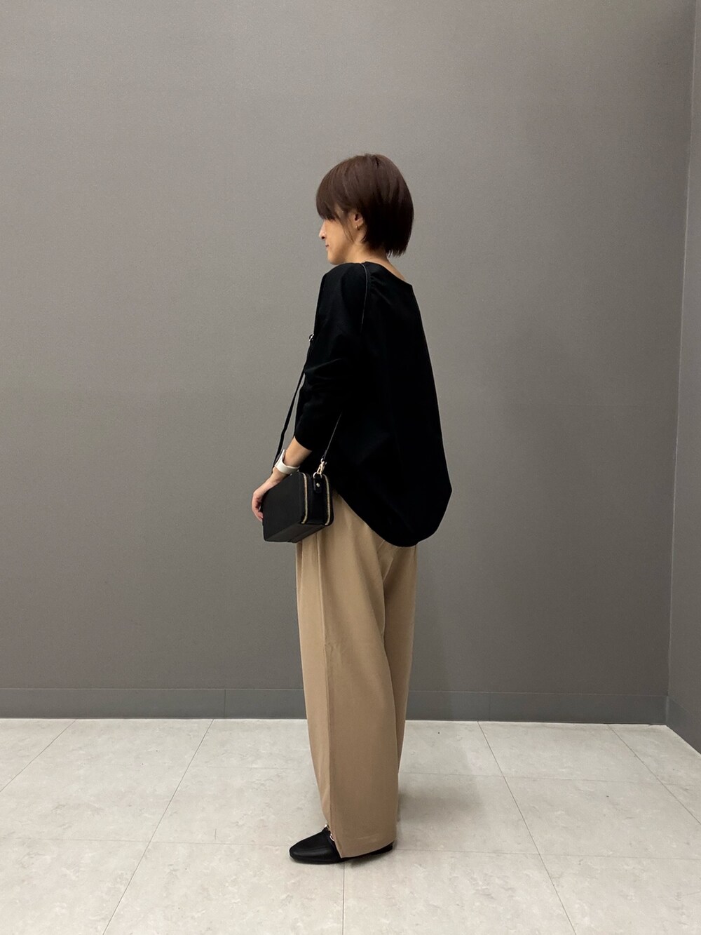 ブラック系のTシャツ/カットソー、ブラック系のショルダーバッグ、ベージュ系のその他パンツを着用したレディースの秋コーディネートの3枚目の写真