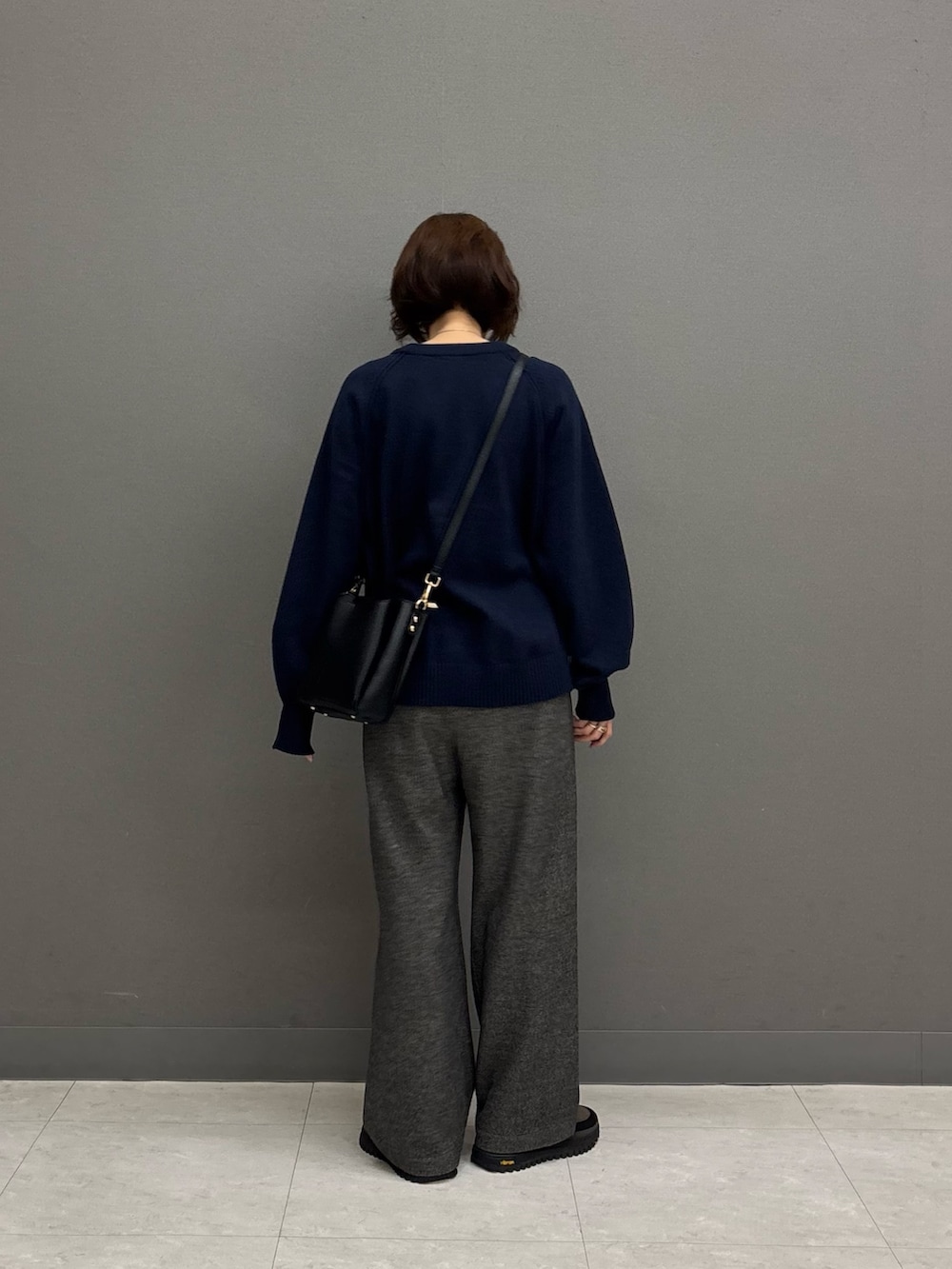 ブラック系のショルダーバッグ、グレー系のその他パンツ、ブルー系のニット/セーターを着用したレディースの冬コーディネートの3枚目の写真