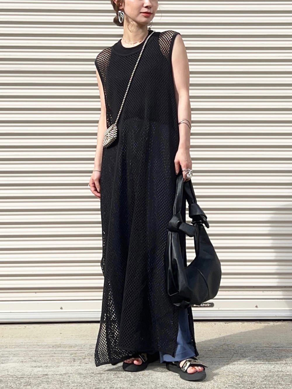 ブラック系のワンピース、ブラック系のタンクトップ、ブルー系のパンツを着用したレディースの夏コーディネートの3枚目の写真