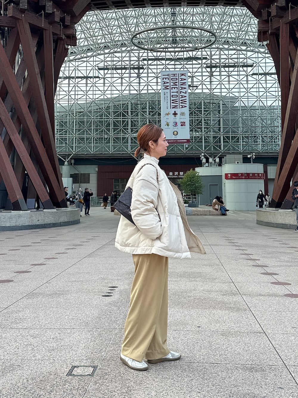 ホワイト系のスニーカー、ベージュ系のスラックス、ホワイト系のニット/セーターを着用したレディースの冬コーディネートの3枚目の写真