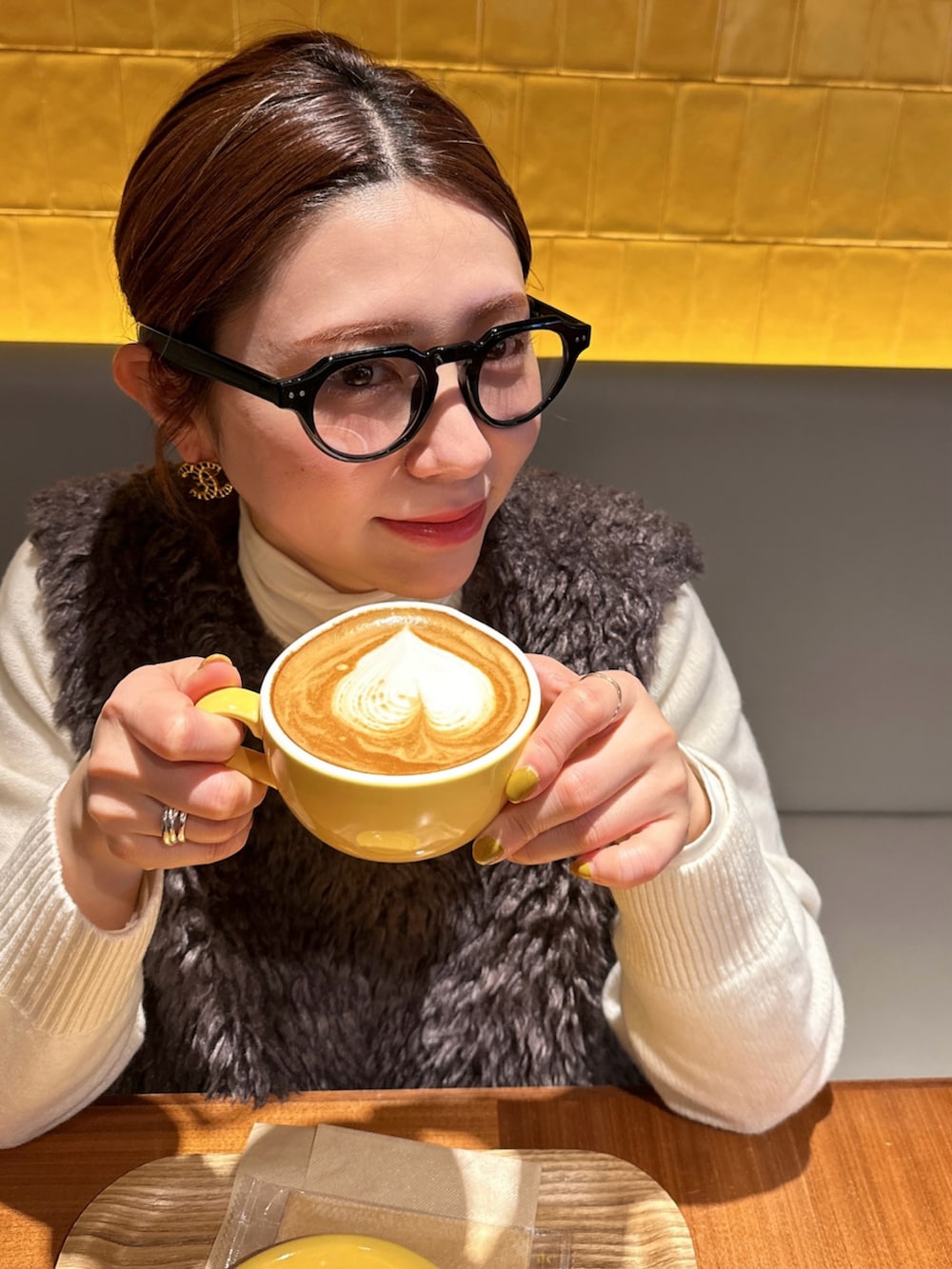 ホワイト系のスニーカー、ベージュ系のスラックス、ホワイト系のニット/セーターを着用したレディースの冬コーディネートの2枚目の写真