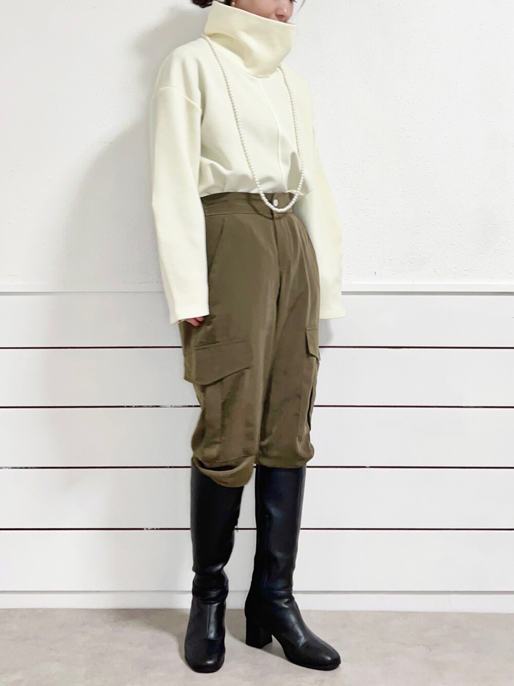 ブラック系のブーツ、グリーン系のカーゴパンツ、ホワイト系のダウンジャケット/コートを着用したレディースの冬コーディネートの3枚目の写真