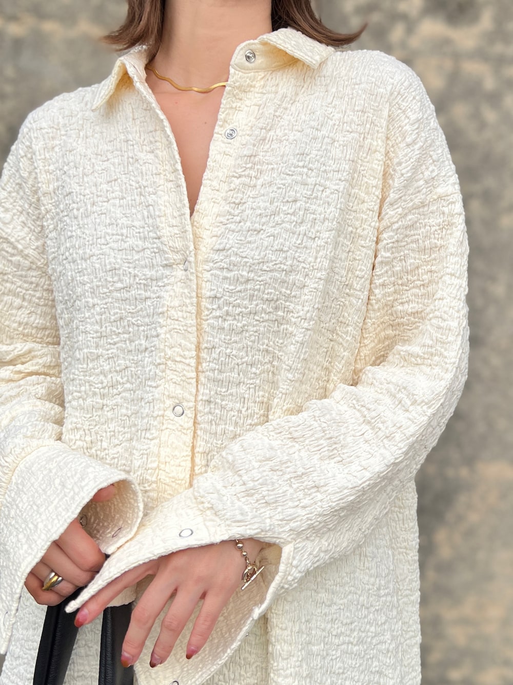 ホワイト系のシャツ/ブラウス、ブラウン系のスカート、ブラック系のブーツを着用したレディースの秋コーディネートの3枚目の写真