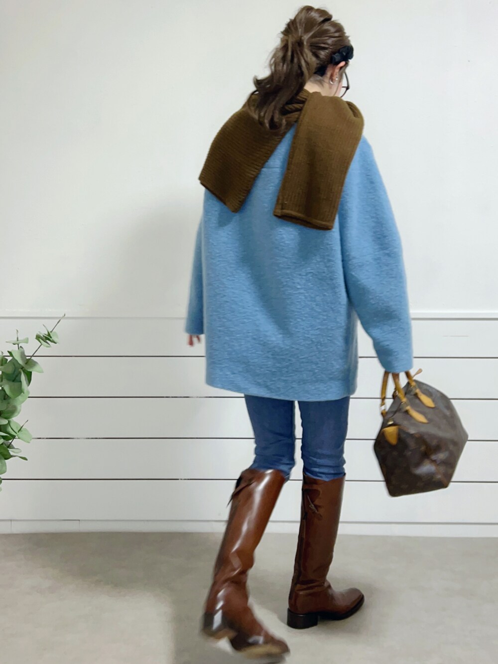 ブルー系のトップス、ブルー系のデニムパンツ、ブラウン系のブーツを着用したレディースの冬コーディネートの2枚目の写真