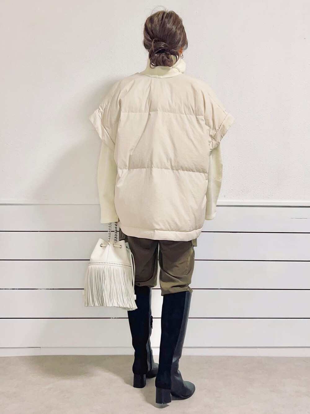 ブラック系のブーツ、グリーン系のカーゴパンツ、ホワイト系のダウンジャケット/コートを着用したレディースの冬コーディネートの2枚目の写真