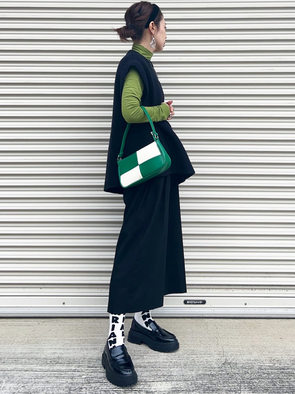 ブラック系のニット/セーター、ブラック系のその他パンツ、ブラック系のローファーを着用したレディースの冬コーディネートの2枚目の写真