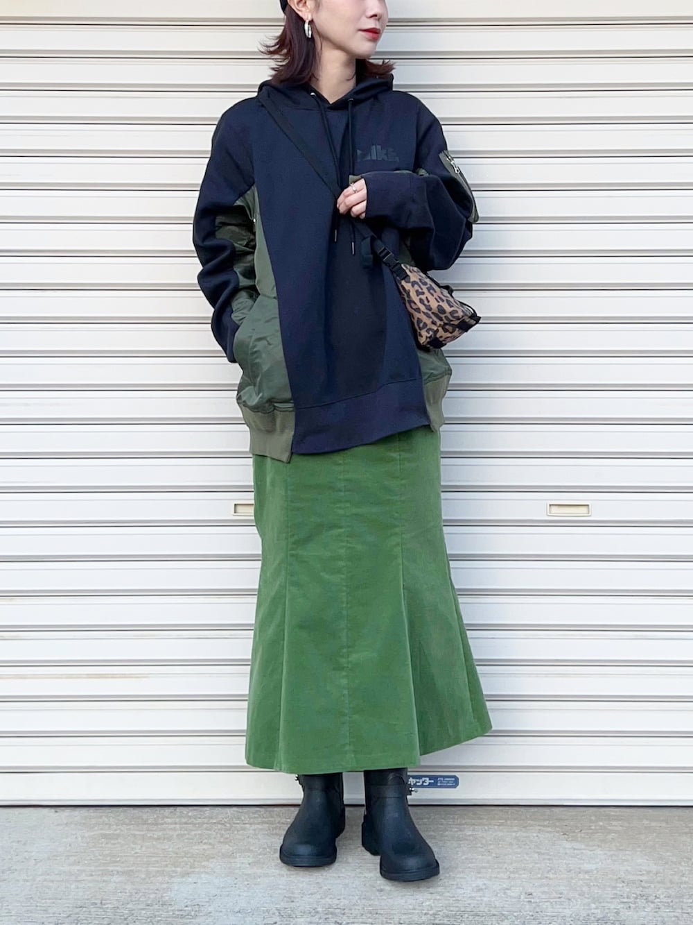 グリーン系のスカート、ブルー系のパーカー、その他のボディバッグ/ウエストポーチを着用したレディースの冬コーディネートの2枚目の写真