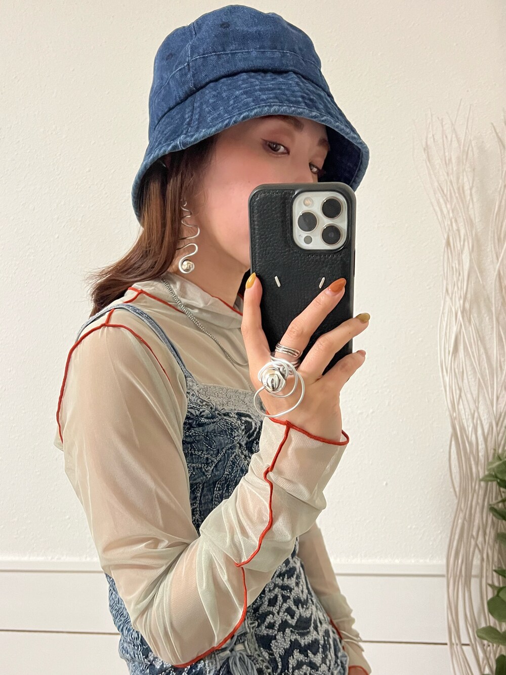 グリーン系のTシャツ/カットソー、ブルー系のハンドバッグ、ブラック系のスカートを着用したレディースの春コーディネートの4枚目の写真