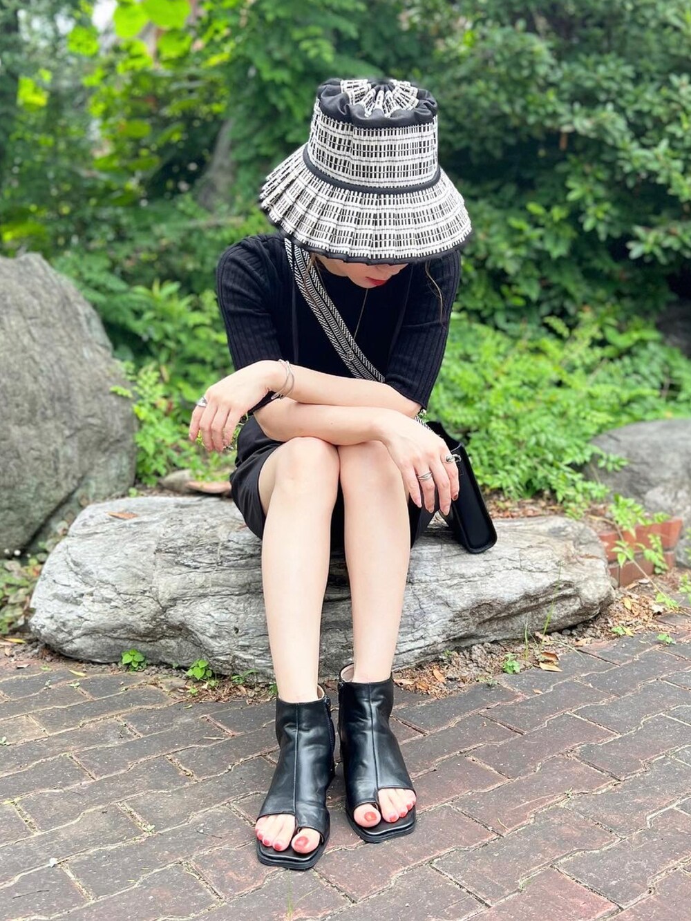 ブラック系のサンダル、ブラック系のパンツ、ブラック系のニット/セーターを着用したレディースの夏コーディネートの2枚目の写真