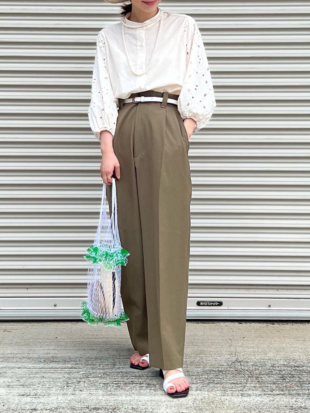 ベージュ系のシャツ/ブラウス、グリーン系のパンツ、ホワイト系のバッグを着用したレディースの夏コーディネートの3枚目の写真