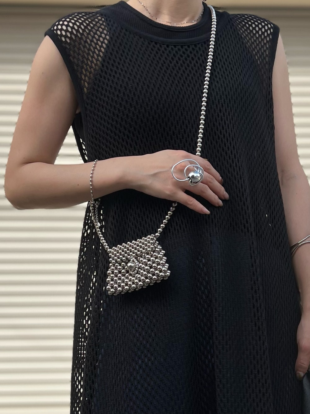 ブラック系のワンピース、ブラック系のタンクトップ、ブルー系のパンツを着用したレディースの夏コーディネートの2枚目の写真