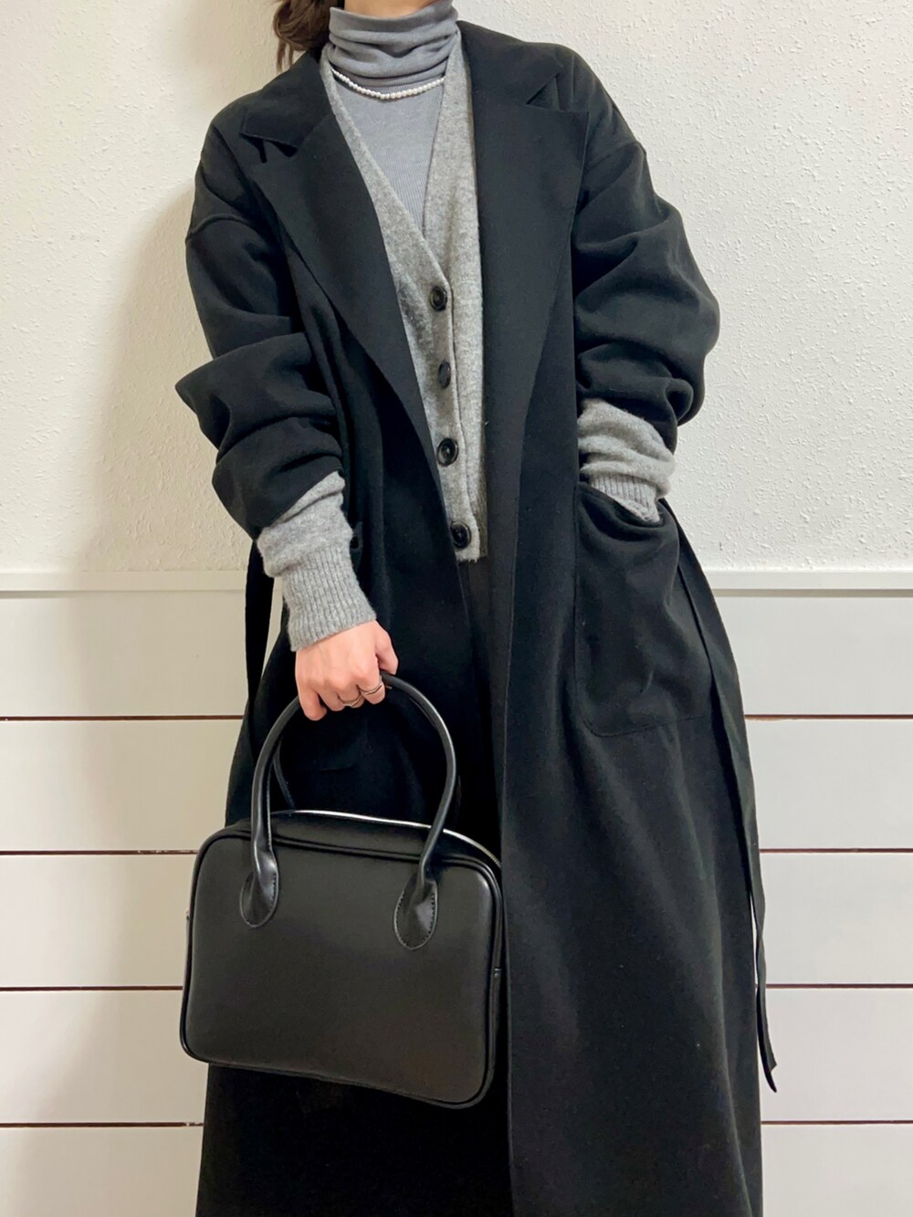 ブラック系のショルダーバッグ、グレー系のスニーカー、グレー系のスラックスを着用したレディースの冬コーディネートの2枚目の写真