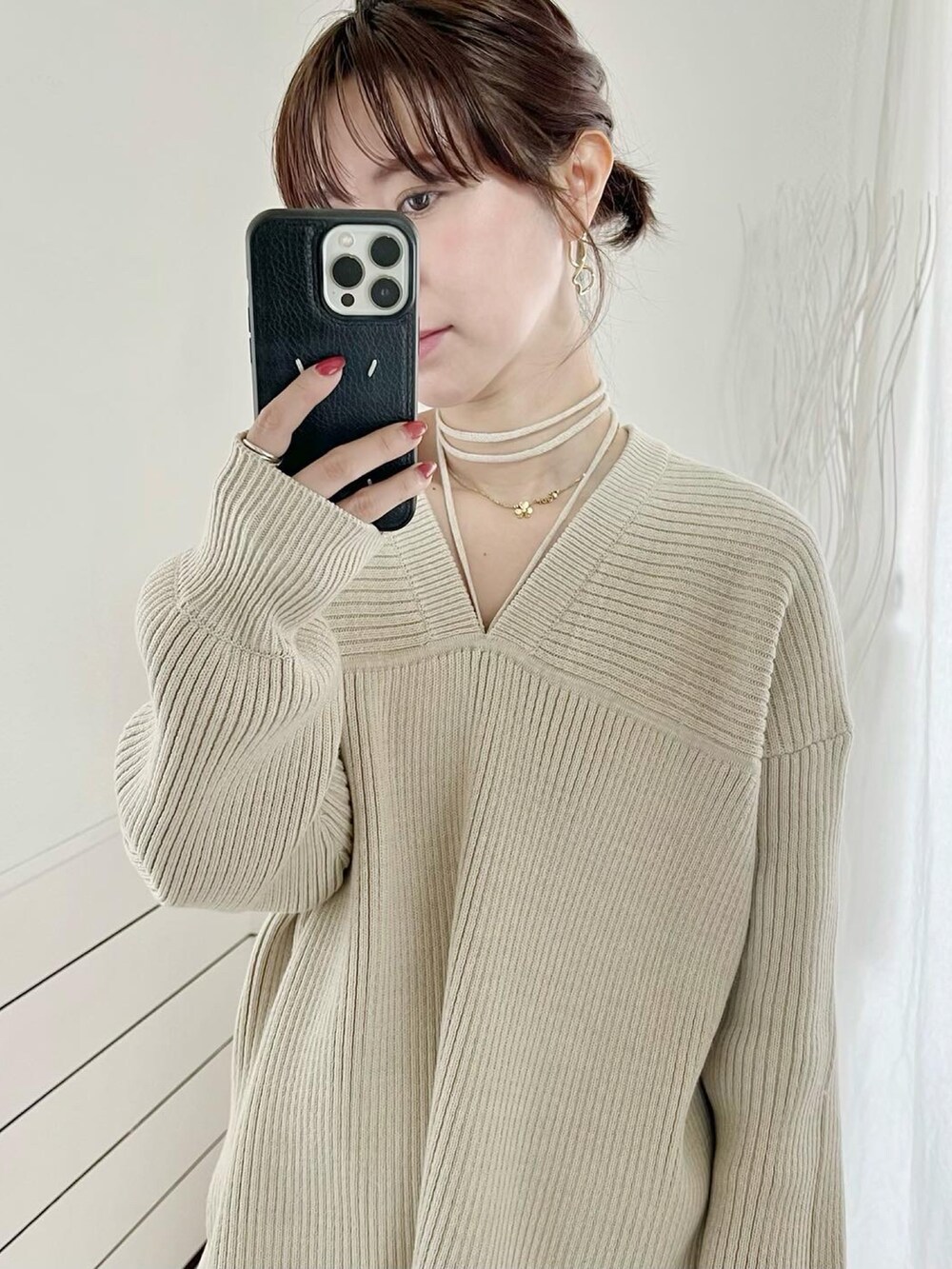 ホワイト系のニット/セーター、ホワイト系のスラックス、ベージュ系のブーツを着用したレディースの冬コーディネートの5枚目の写真