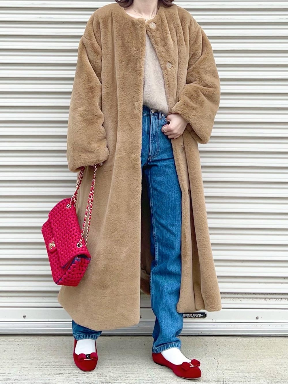 レッド系のバレエシューズ、ホワイト系のニット/セーター、ブルー系のデニムパンツを着用したレディースの冬コーディネートの4枚目の写真