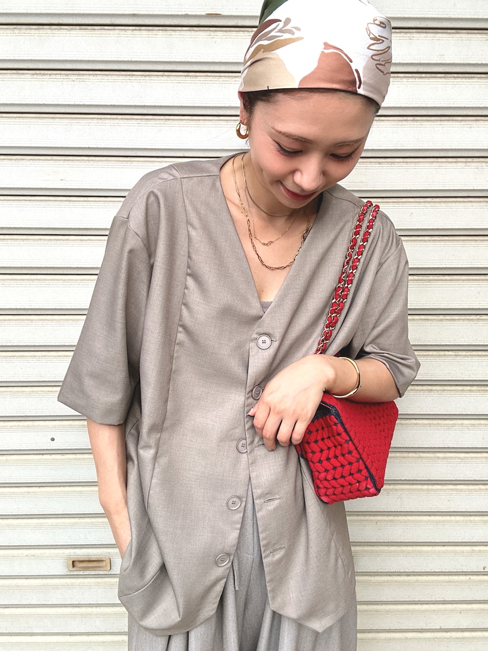 ベージュ系のスラックス、ゴールド系のパンプス、ベージュ系のノーカラージャケットを着用したレディースの秋コーディネートの2枚目の写真