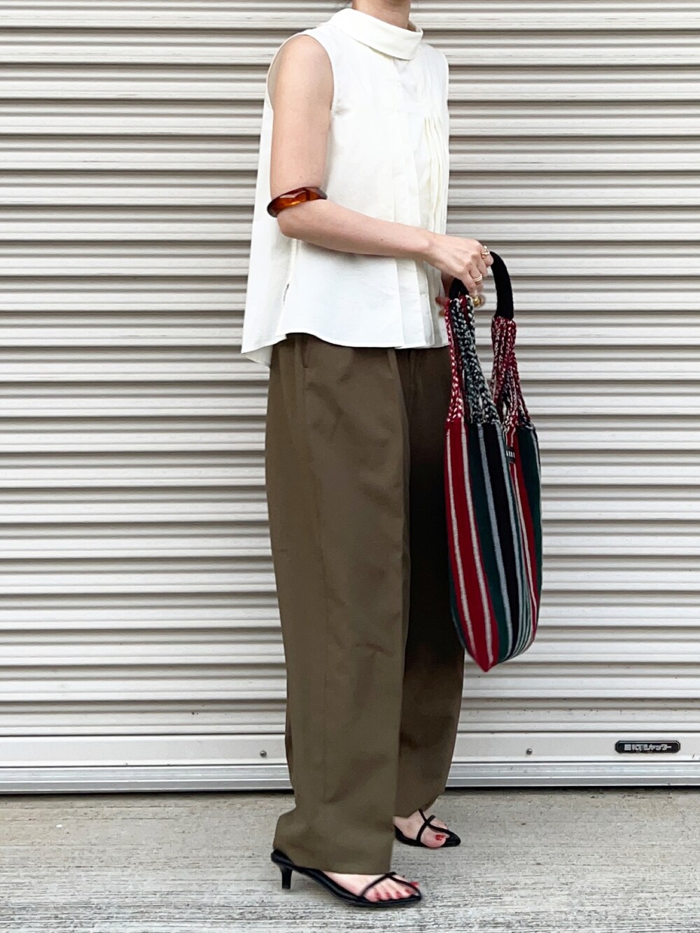グリーン系のパンツ、ホワイト系のシャツ/ブラウスを着用したレディースの春コーディネートの2枚目の写真