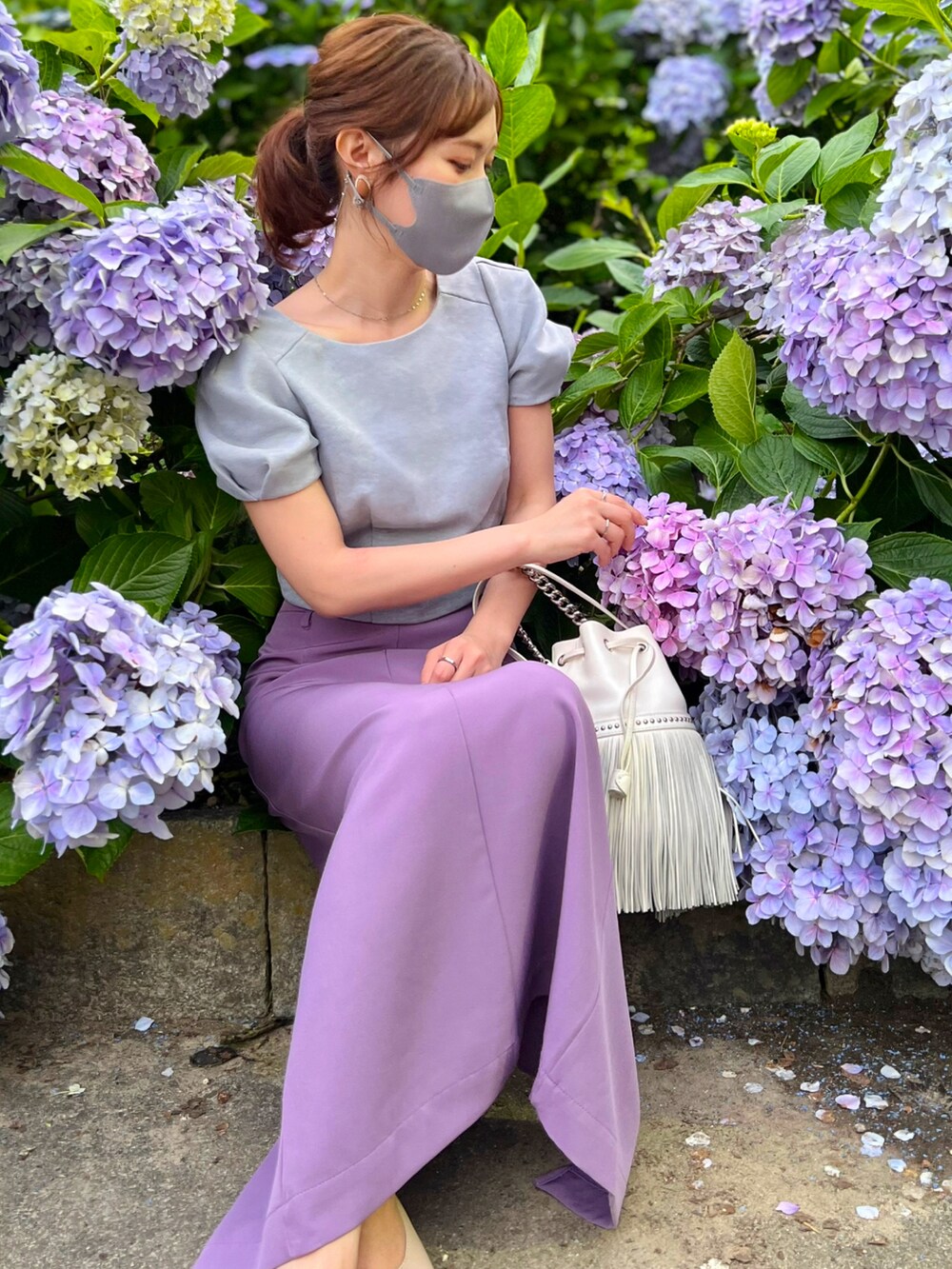 グレー系のトップス、パープル系のスカート、ベージュ系のシューズを着用したレディースの夏コーディネートの2枚目の写真