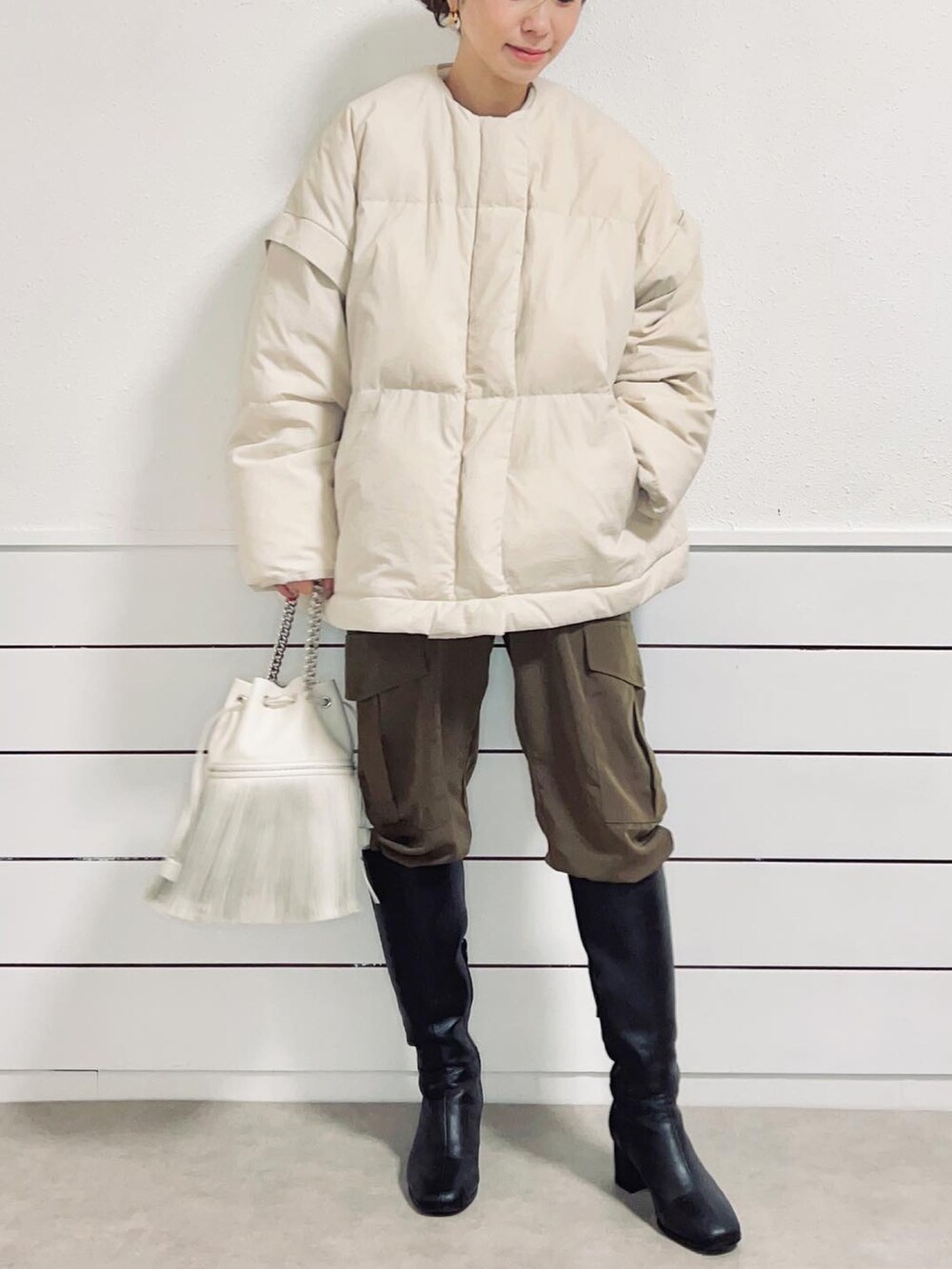 ブラック系のブーツ、グリーン系のカーゴパンツ、ホワイト系のダウンジャケット/コートを着用したレディースの冬コーディネートの4枚目の写真