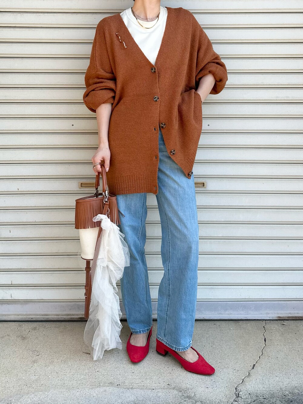 レッド系のパンプス、ブルー系のデニムパンツ、オレンジ系のカーディガン/ボレロを着用したレディースの夏コーディネートの2枚目の写真