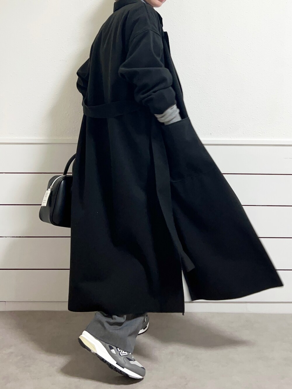 ブラック系のショルダーバッグ、グレー系のスニーカー、グレー系のスラックスを着用したレディースの冬コーディネートの4枚目の写真