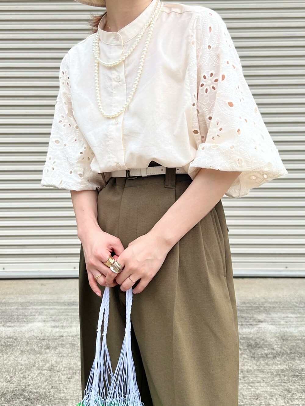 ベージュ系のシャツ/ブラウス、グリーン系のパンツ、ホワイト系のバッグを着用したレディースの夏コーディネートの2枚目の写真