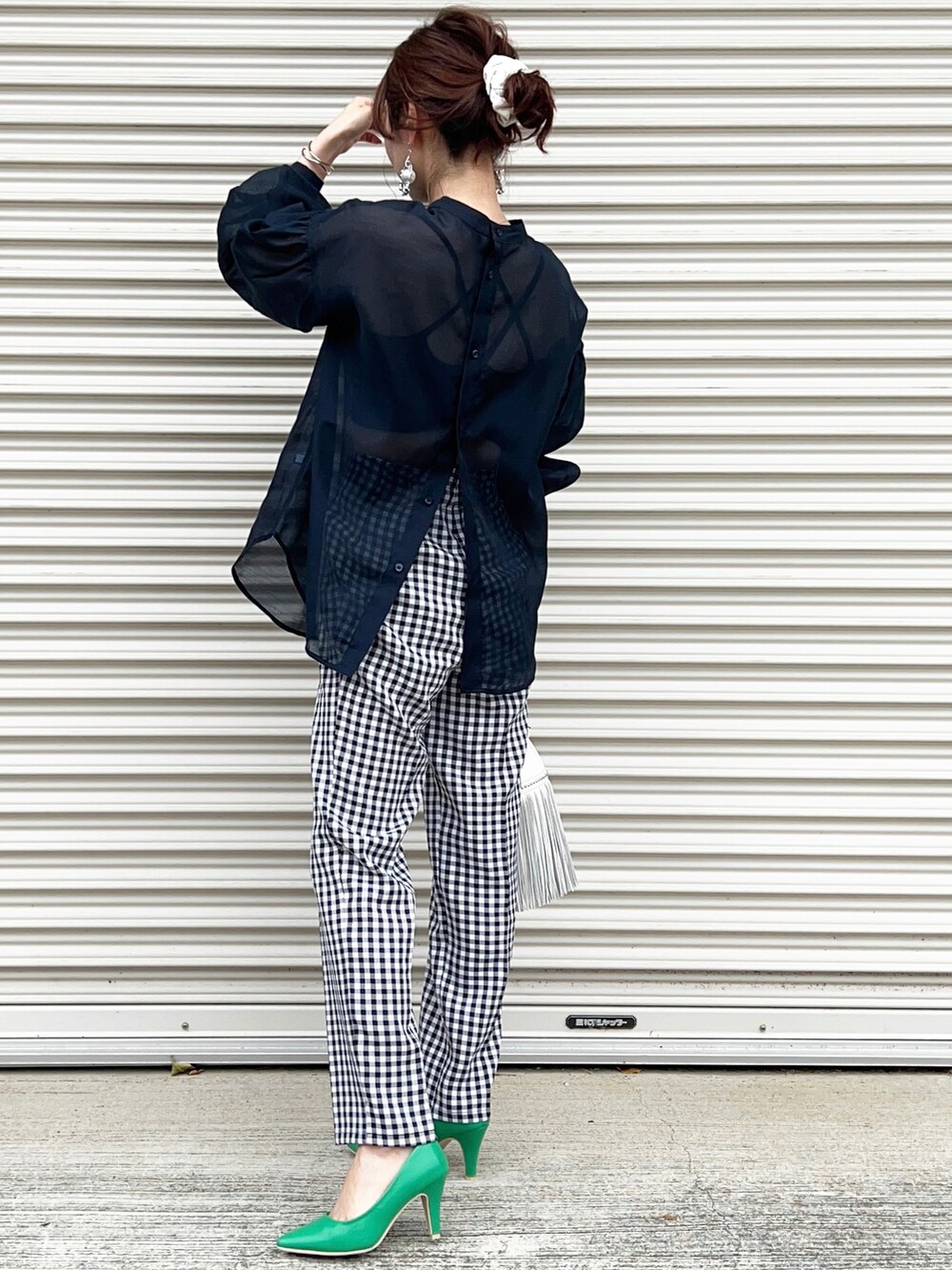 ブラック系のその他パンツ、グリーン系のパンプス、ホワイト系のショルダーバッグを着用したレディースの春コーディネートの2枚目の写真