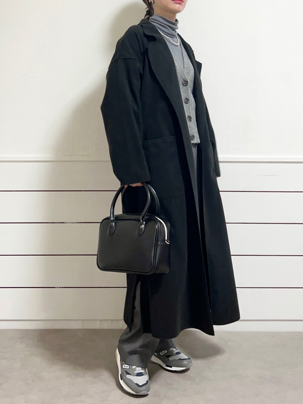ブラック系のショルダーバッグ、グレー系のスニーカー、グレー系のスラックスを着用したレディースの冬コーディネートの3枚目の写真